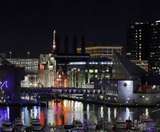 photo of downtown Baltimore Inner Harbor with marina in foreground and aquarium in background