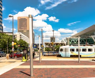 photo of downtown Baltimore with light rail train and convention center in background